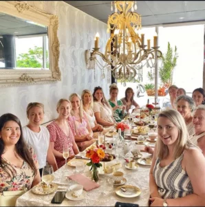 group of girls at a beautiful designed table to celebrate their friends baby shower. 